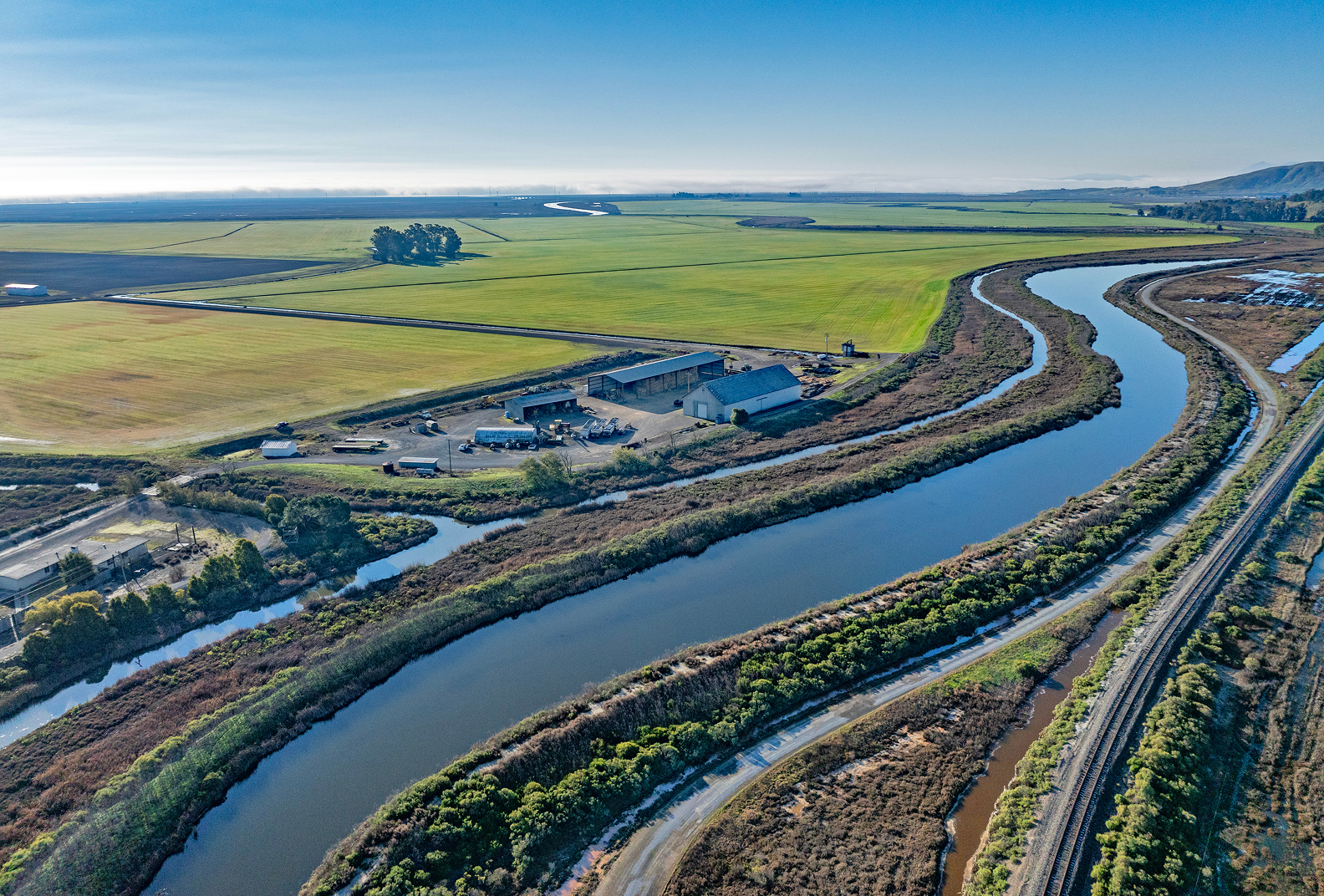A gathering of farm buildings alongside a waterway at Camp 3.