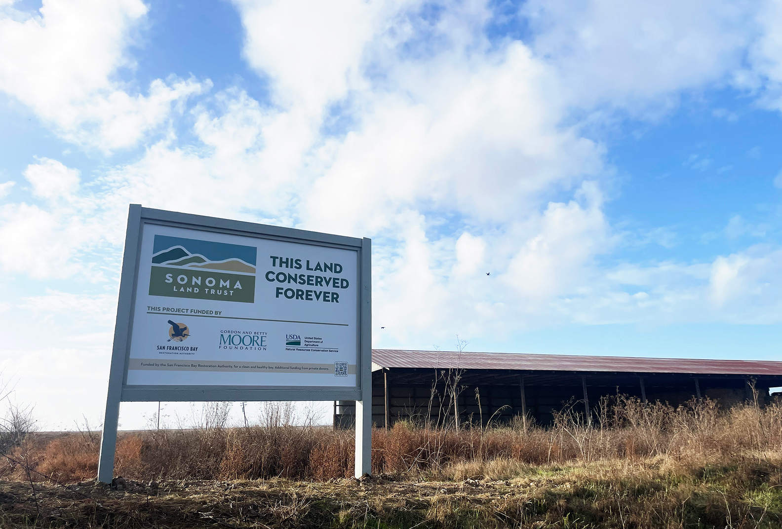 A sign that reads that the land at Camp 4 is protected forever thanks to Sonoma Land Trust and its partners.