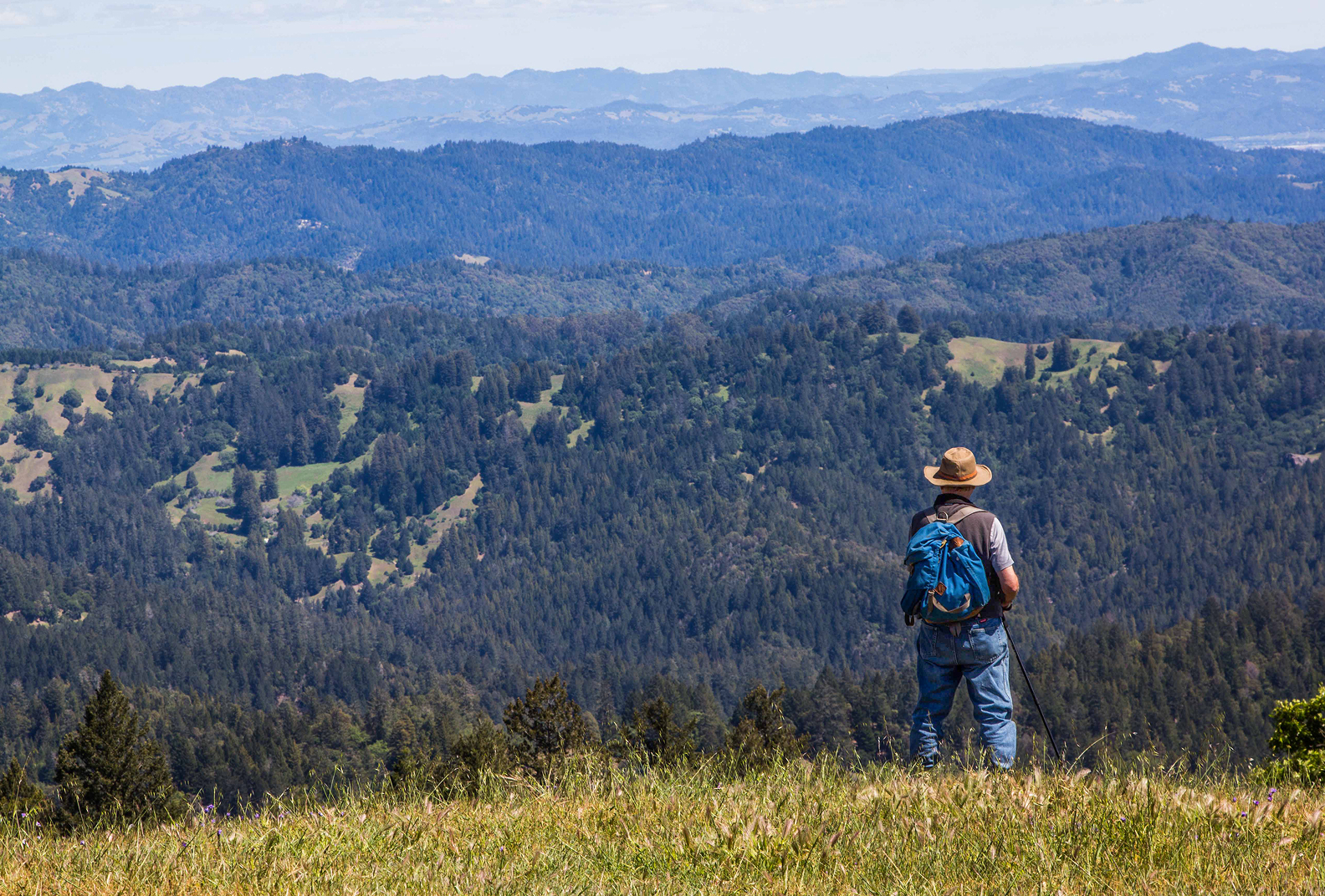 A lone hiker standing and admiring the view of the sweeping landscape at Pole Mountain.