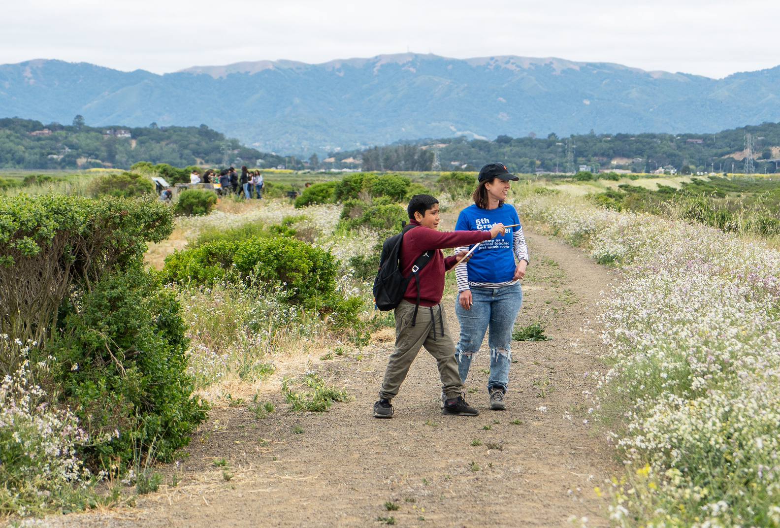 Student points out an observation to a teacher on a hiking trail