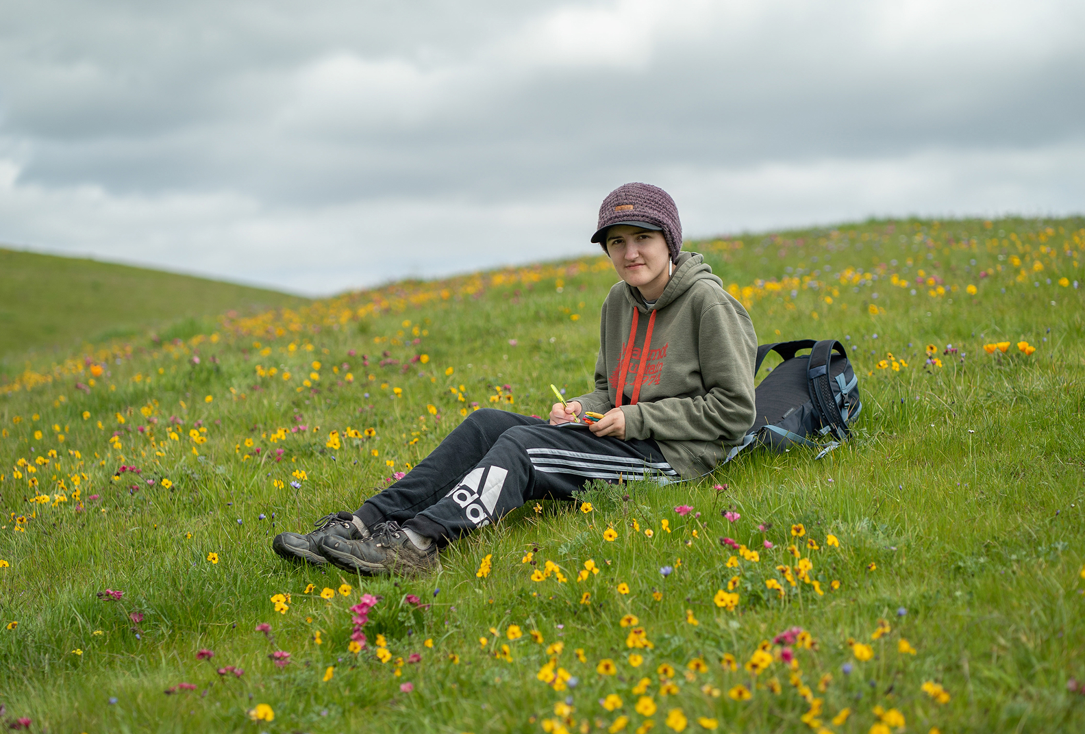 Conservation Council student sitting in a field of wildflowers