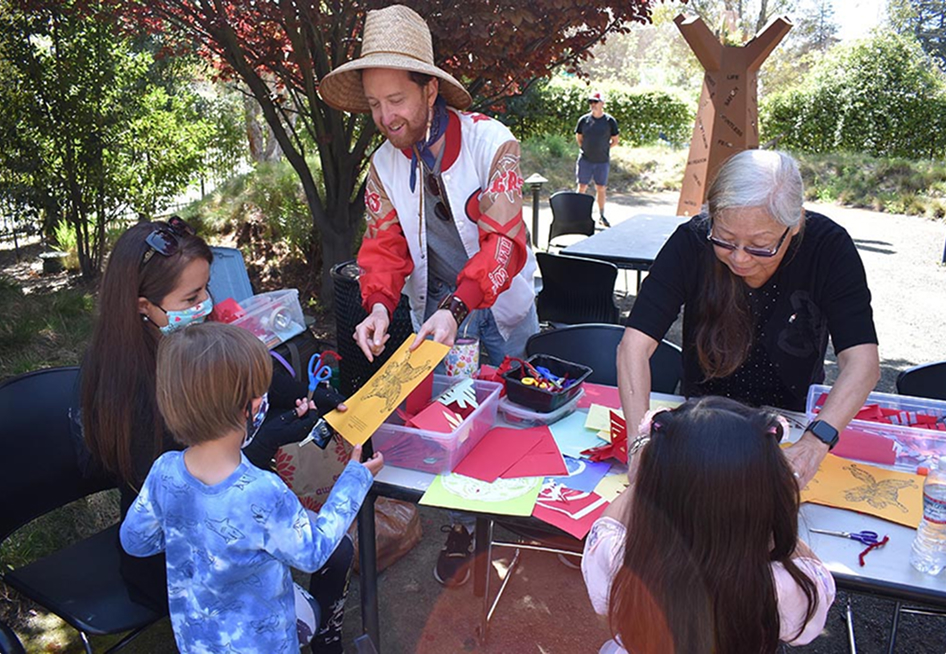 Staff helping kids with coloring project outdoors.