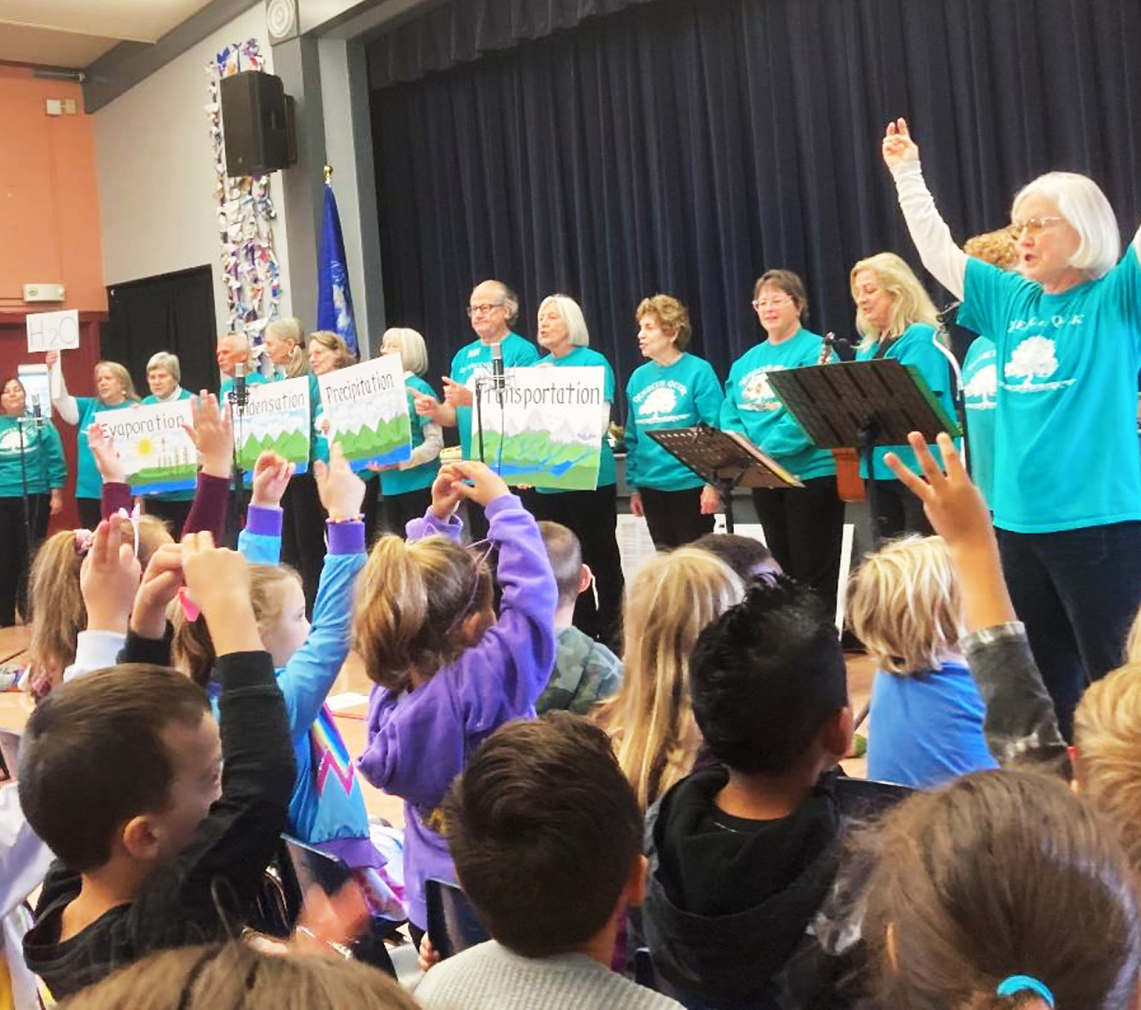 Quercus Quire performing for a group of children indoors.