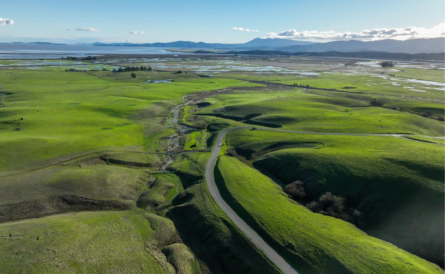 Aerial view of Lakeville Creek with green hills.