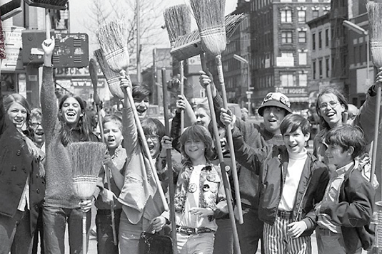 Environmental protesters holding brooms.