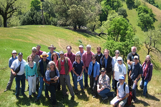 A group of event participants on a green hillside.
